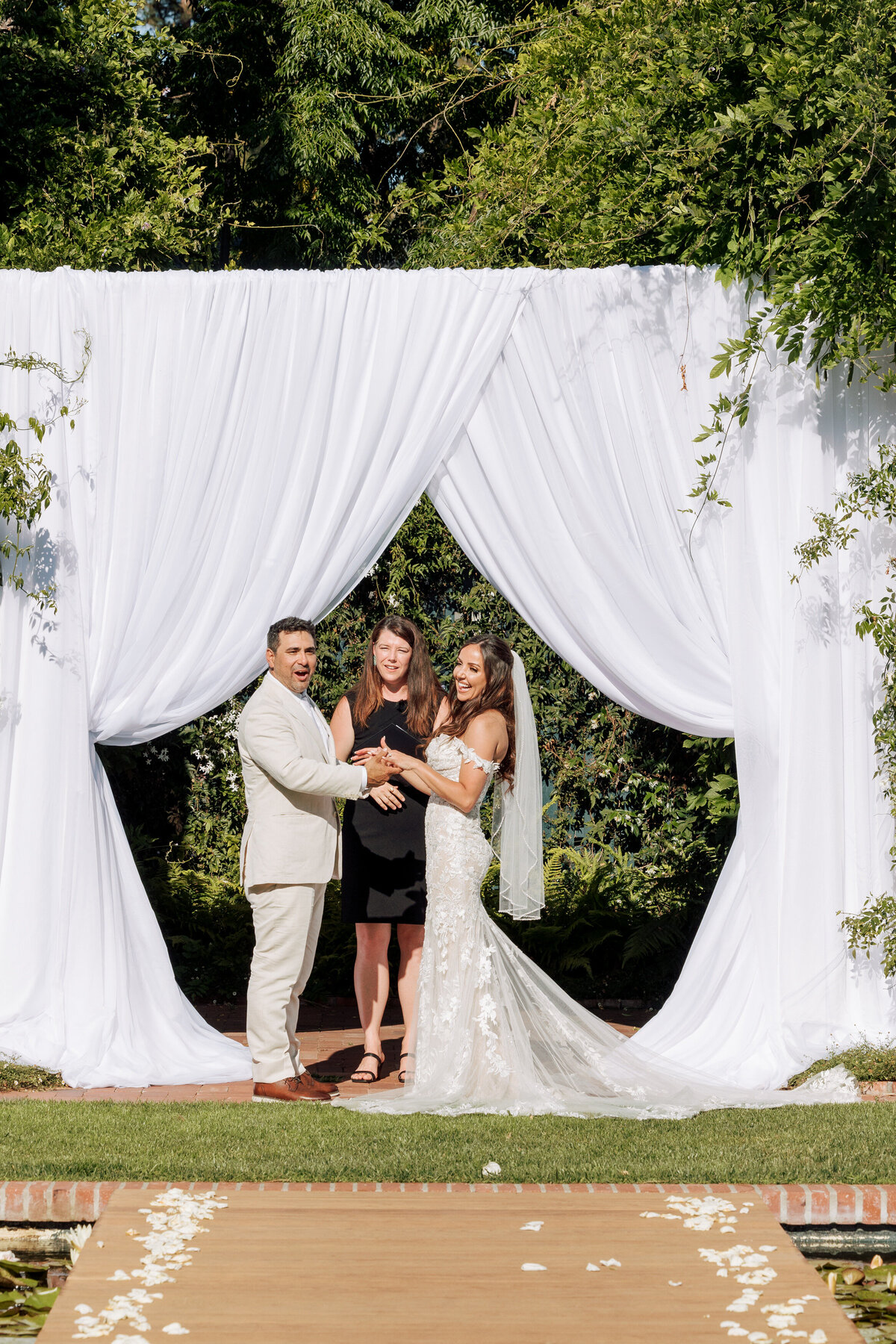 Couple smilling during the ceremony at the Lily Pond at Belmond El Encanto