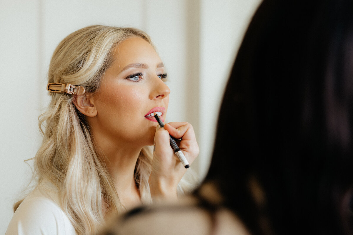 The bride getting her lipstick applied.