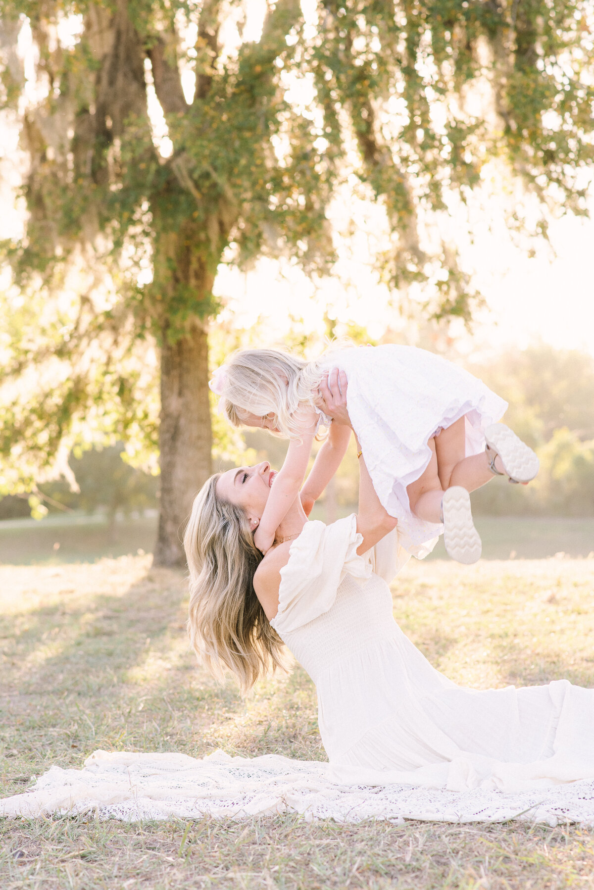 Luxury family photography session in Houston, Texas - beautifully styled Mom and daughter laughing together in a warm, golden-hour glow.