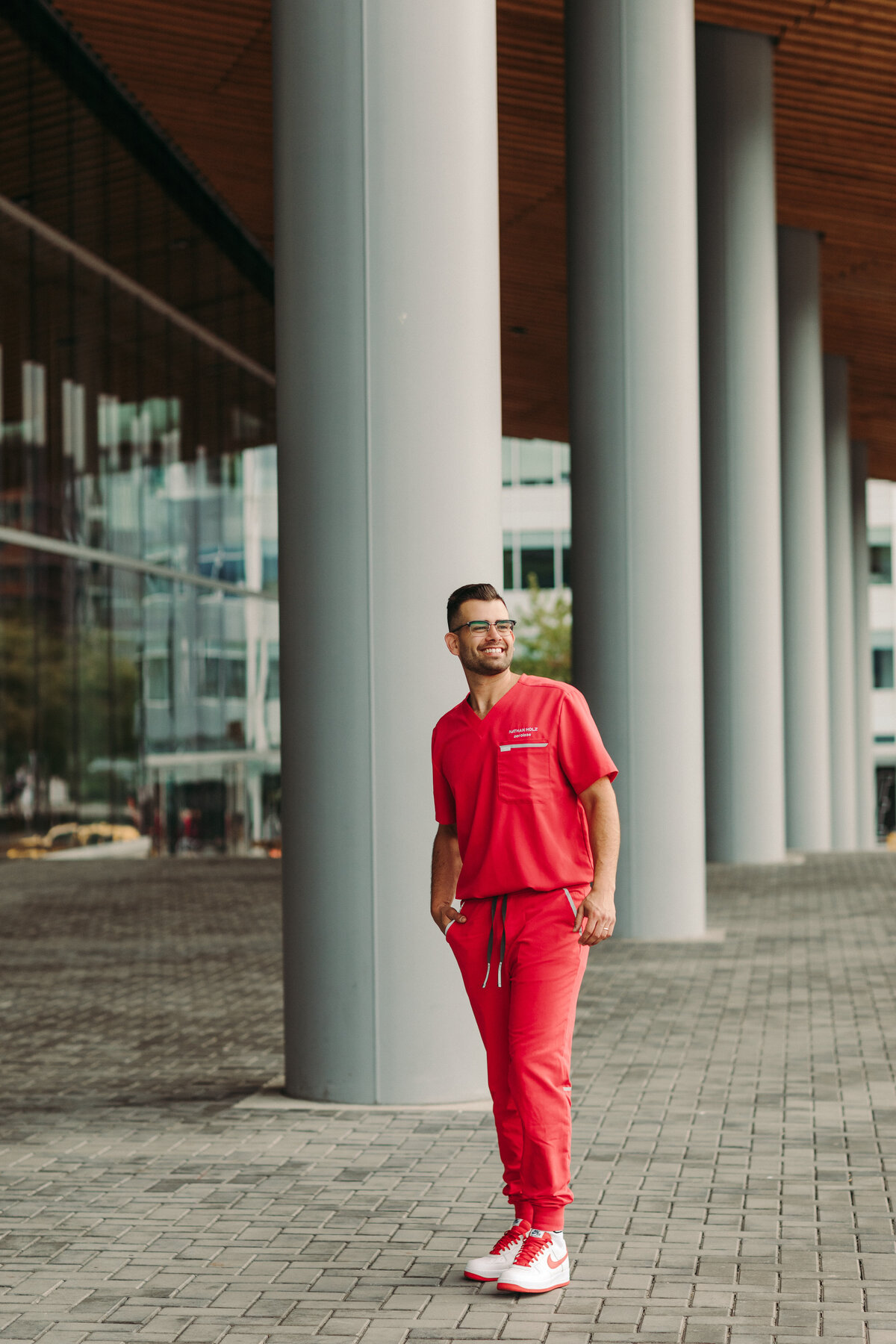 Utah Family Photographer captures man standing in red scrubs during brand photoshoot
