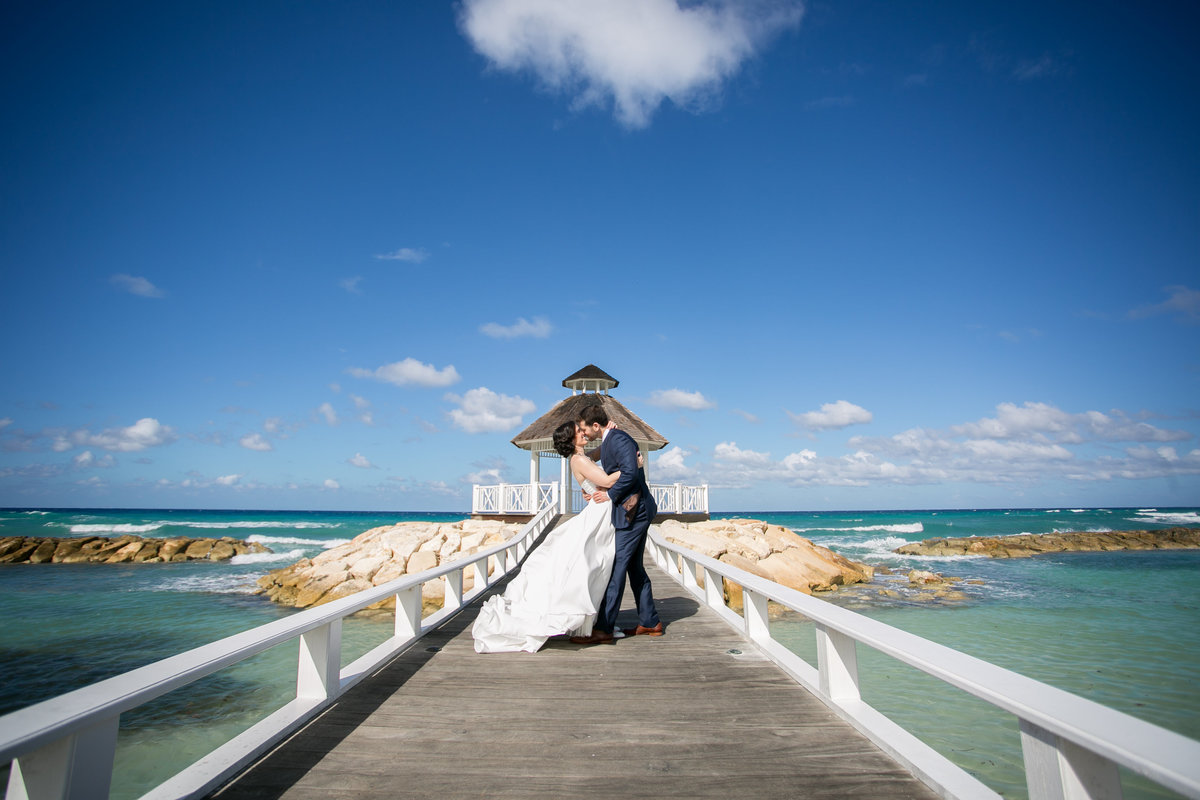 Bride and groom kissing on a dock in Jamaica