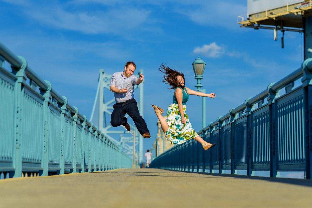 A fun couple playing air guitar on the ben franklin Bridge.