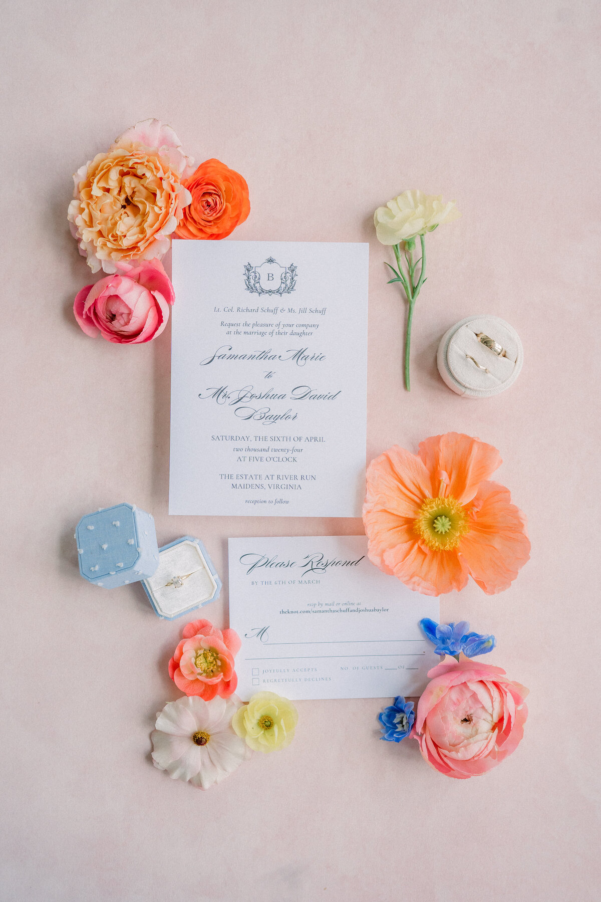 Gorgeous wedding invitation suite surrounded by stunning colorful florals and the bride and groom's rings