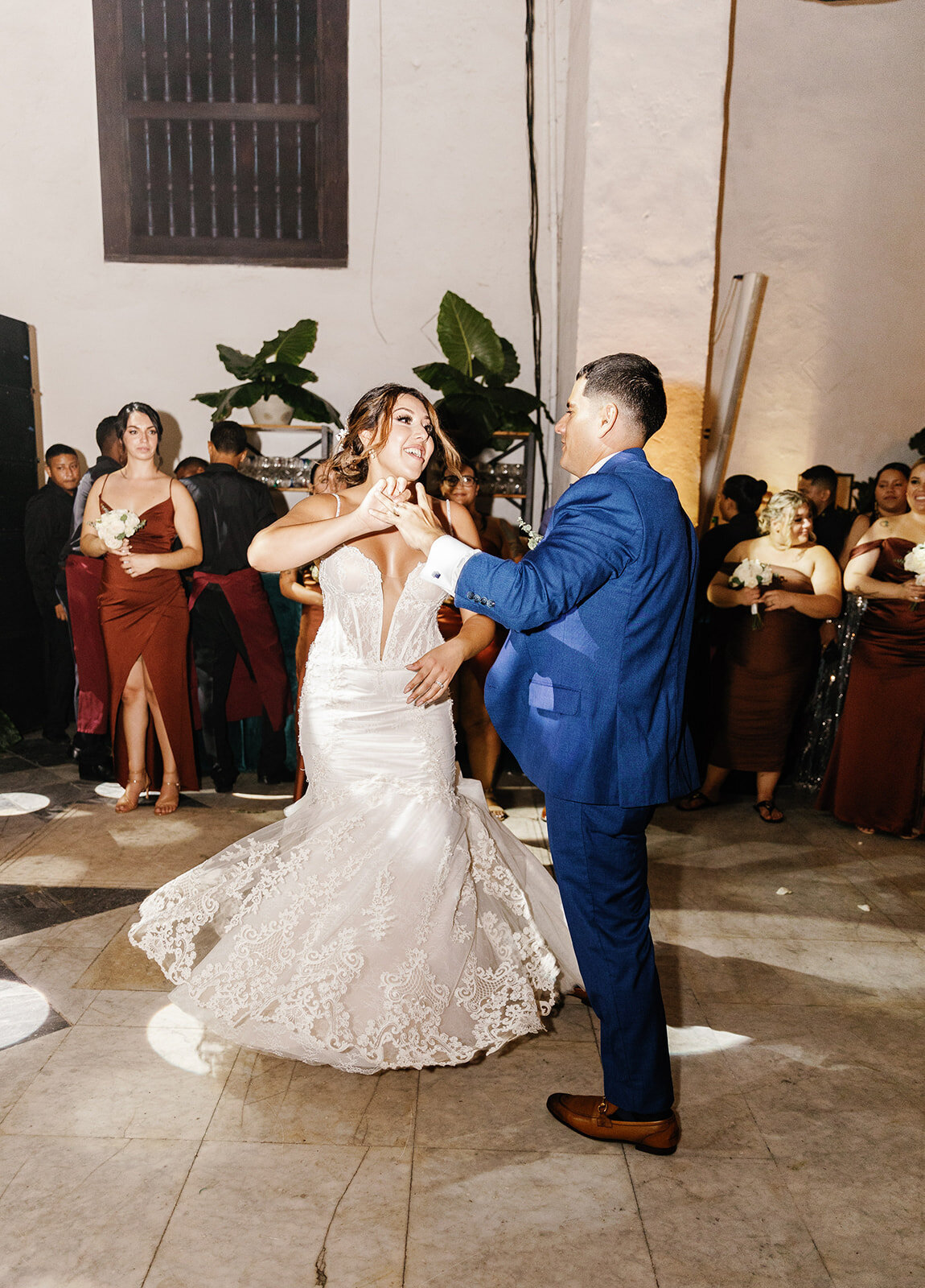 Victoria and Daniel enjoy their first dance, surrounded by family and friends in a candlelit reception space.