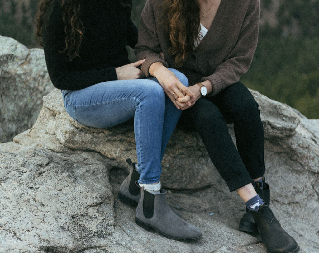 A couple sitting on a rock together.