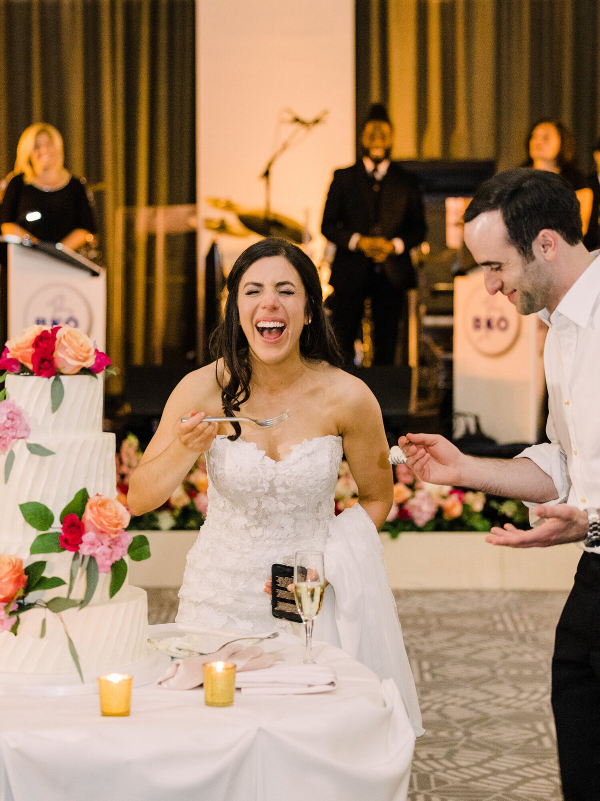 A couple shares a laugh as they cut their wedding cake