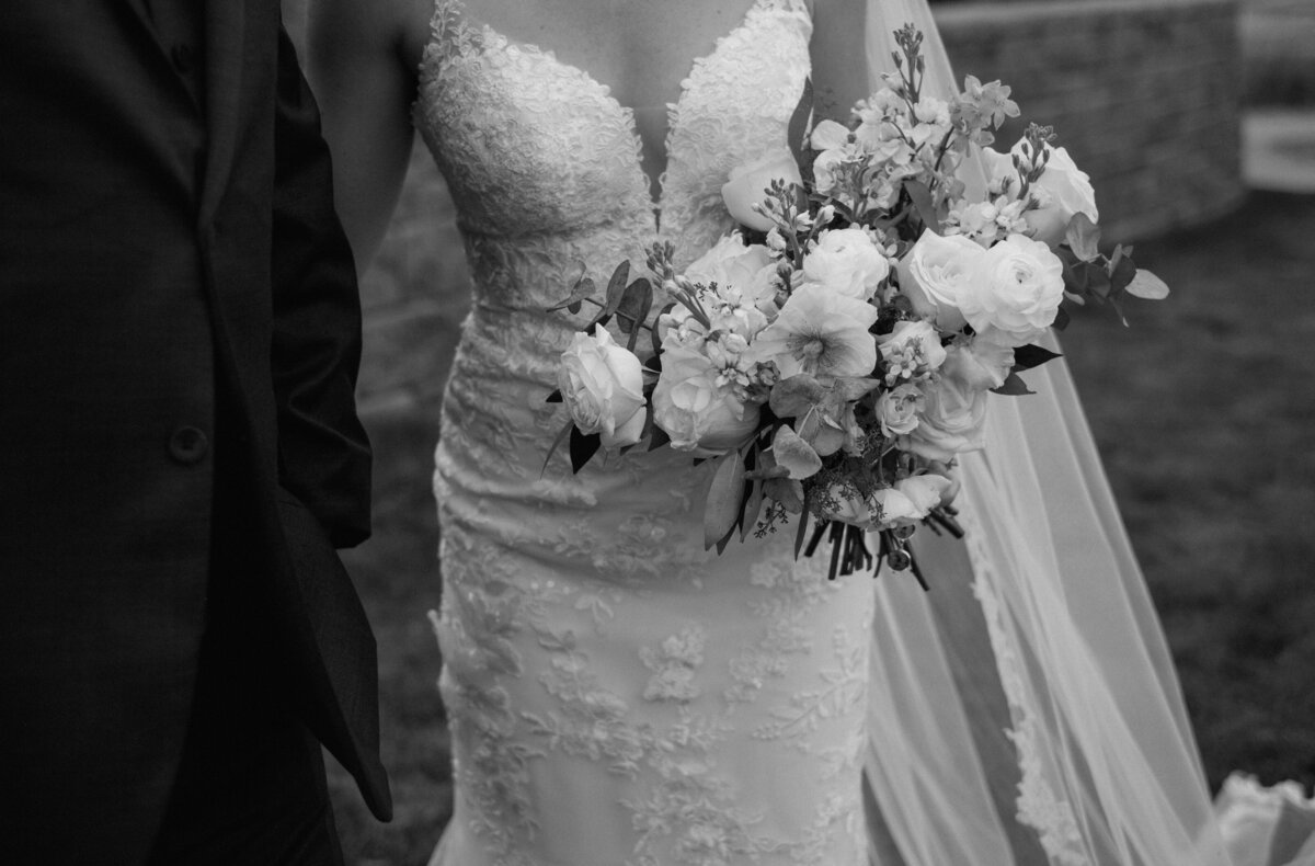 bride and groom walking with floral bouquet in hand