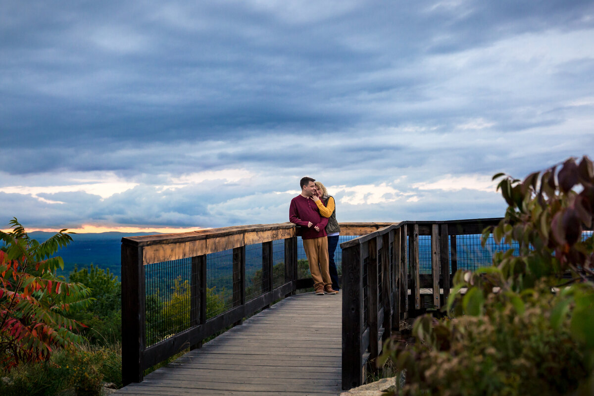 Engaged couple at the top of Mount Agamenticus with a stormy sky