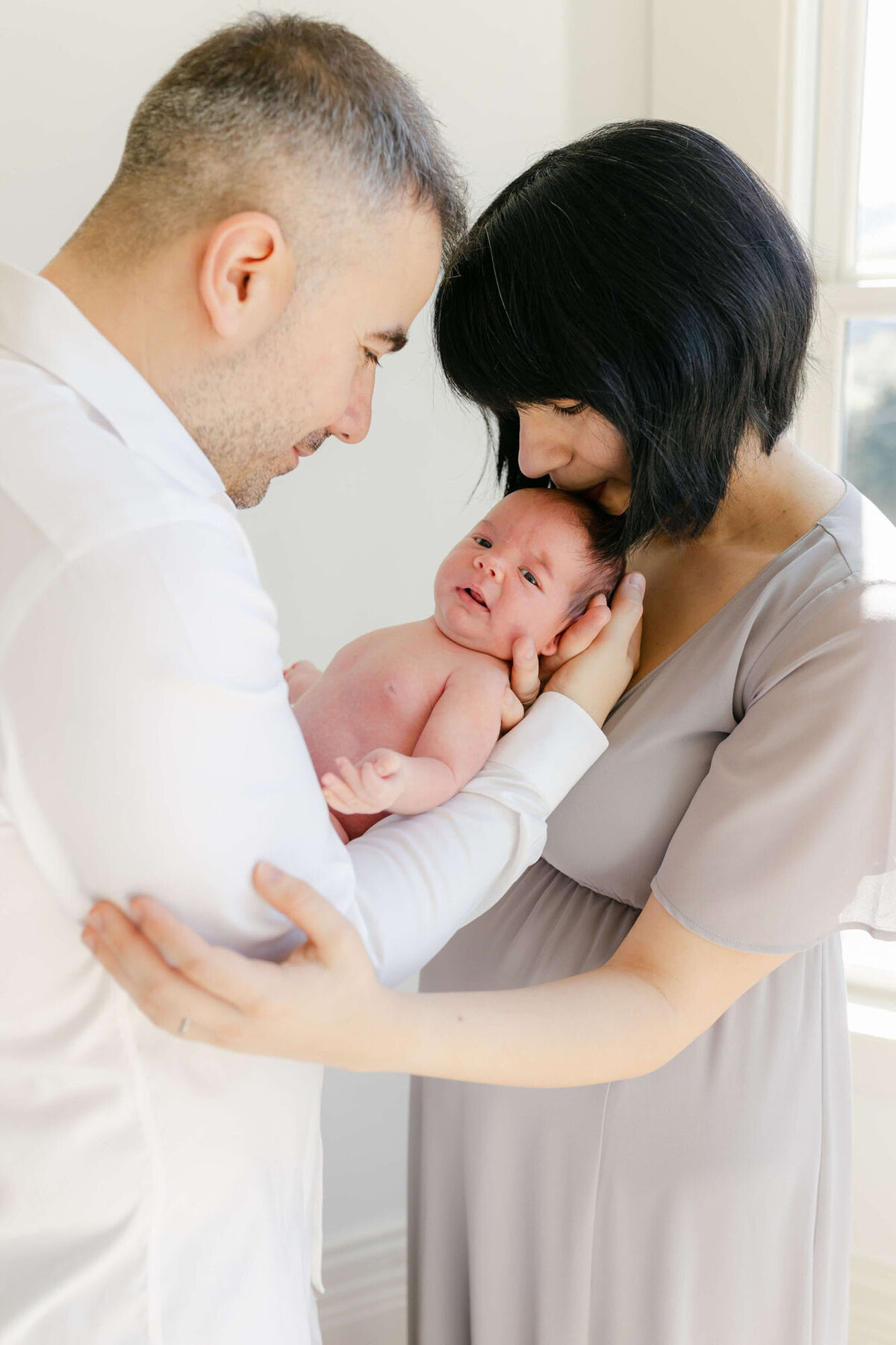 Cozy living room Bay Area newborn photography session with baby wrapped in a blanket.