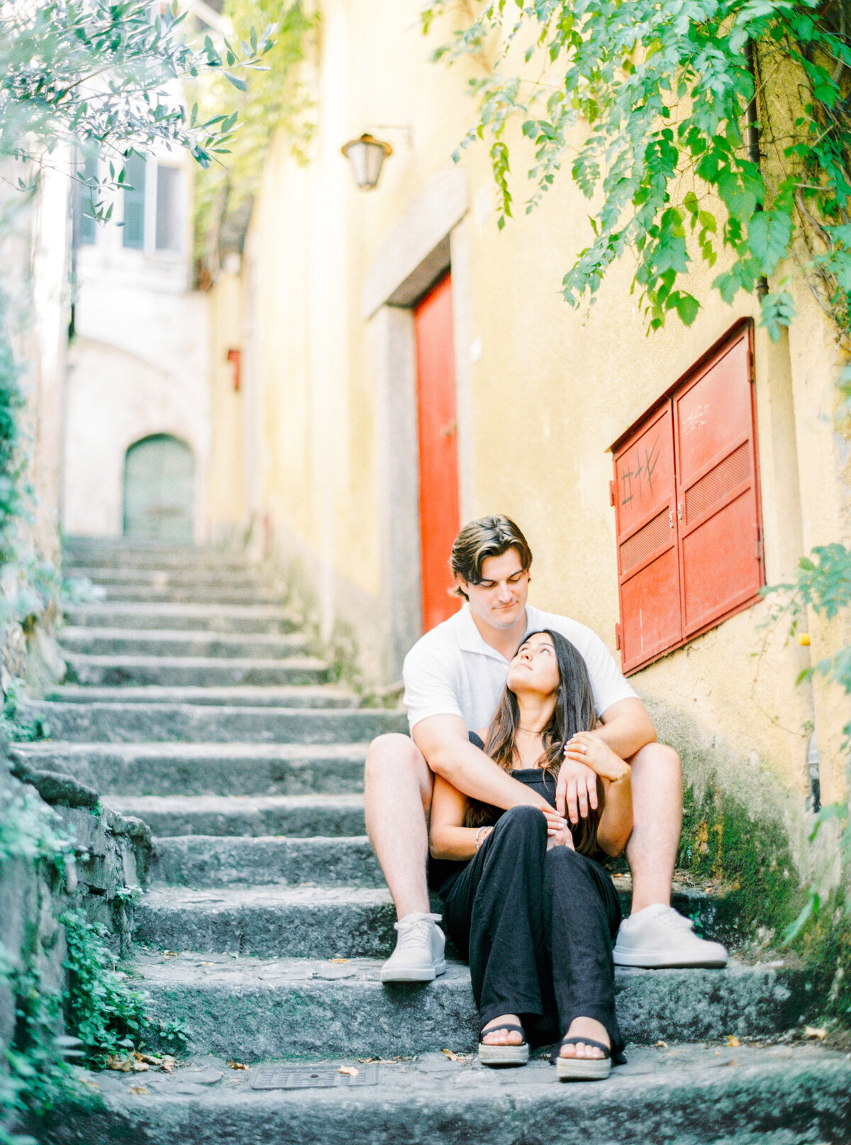 Couple on the steps of Nesso Italy engagement session, photographed by Italy wedding photographer.