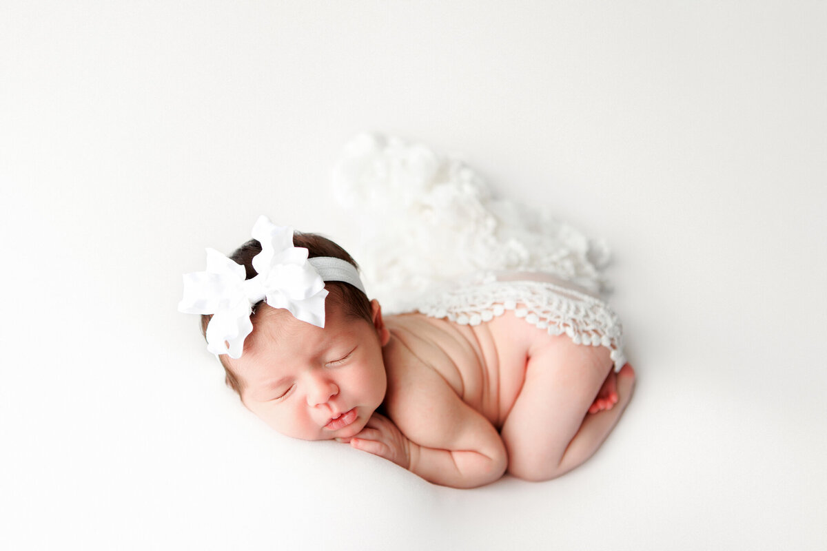 Newborn baby girl gently posed o her tummy by local Fresno photographer Angelia Jansen of One Good Shot Photography