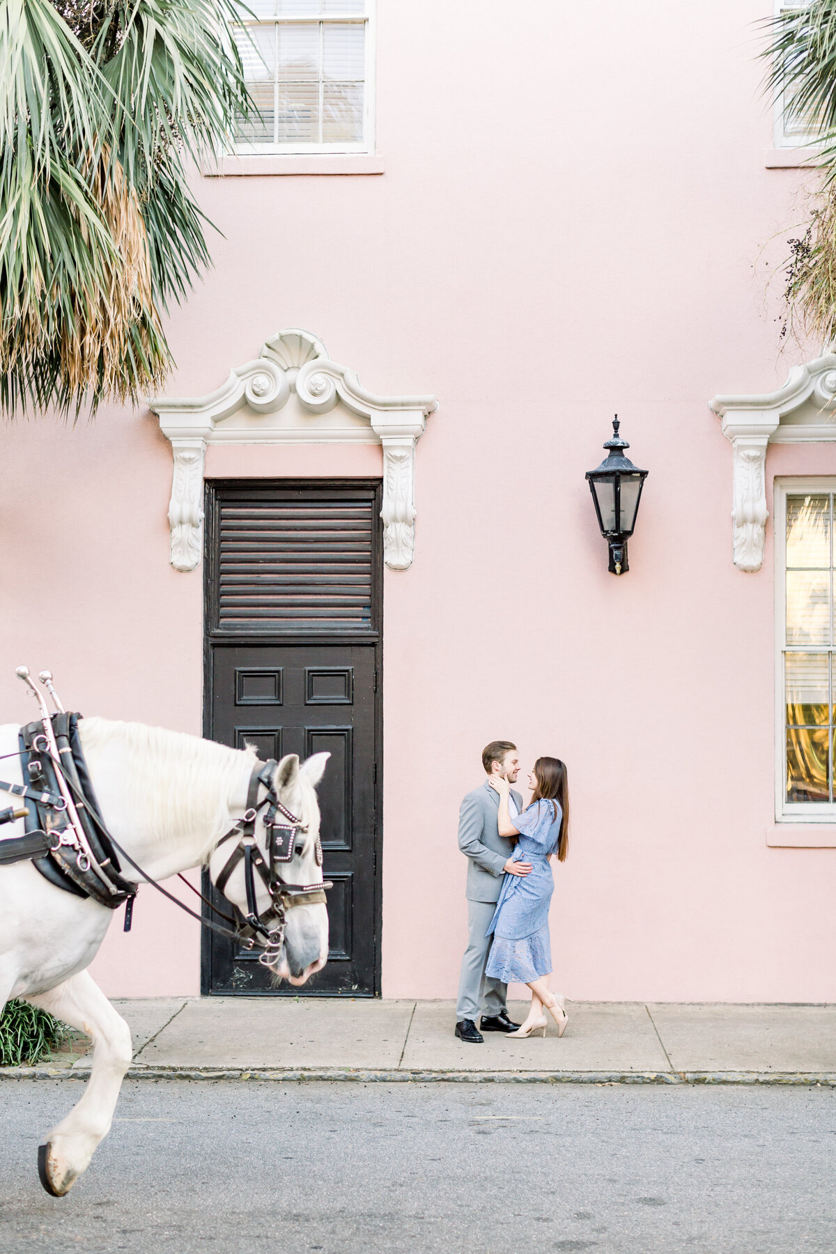 Engaged couple embrace on street outside the Wickliffe House in South Carolina.