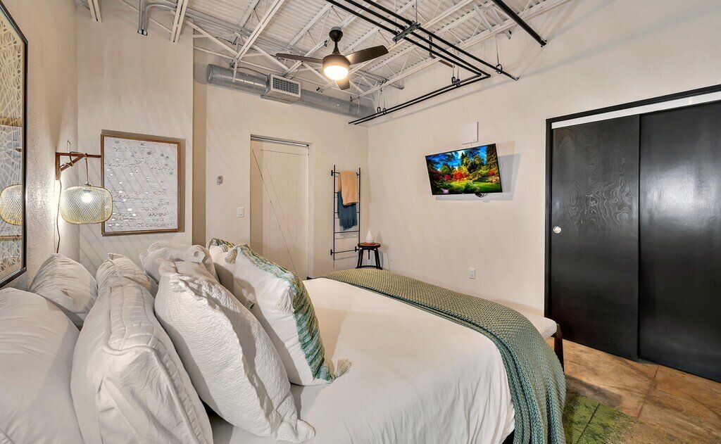 Private master bedroom with TV in this one-bedroom, one-bathroom vacation rental condo with sleeping space for four is walking distance from the Silos, McLane Stadium, and Baylor University in downtown Waco, TX
