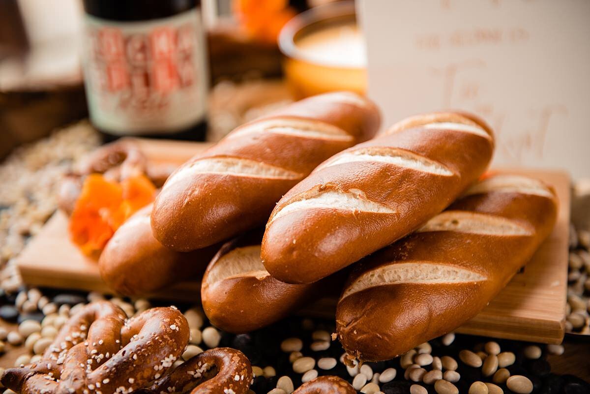 A wooden cutting board stacked with soft pretzels at City Winery Nashville for a wedding cocktail hour.