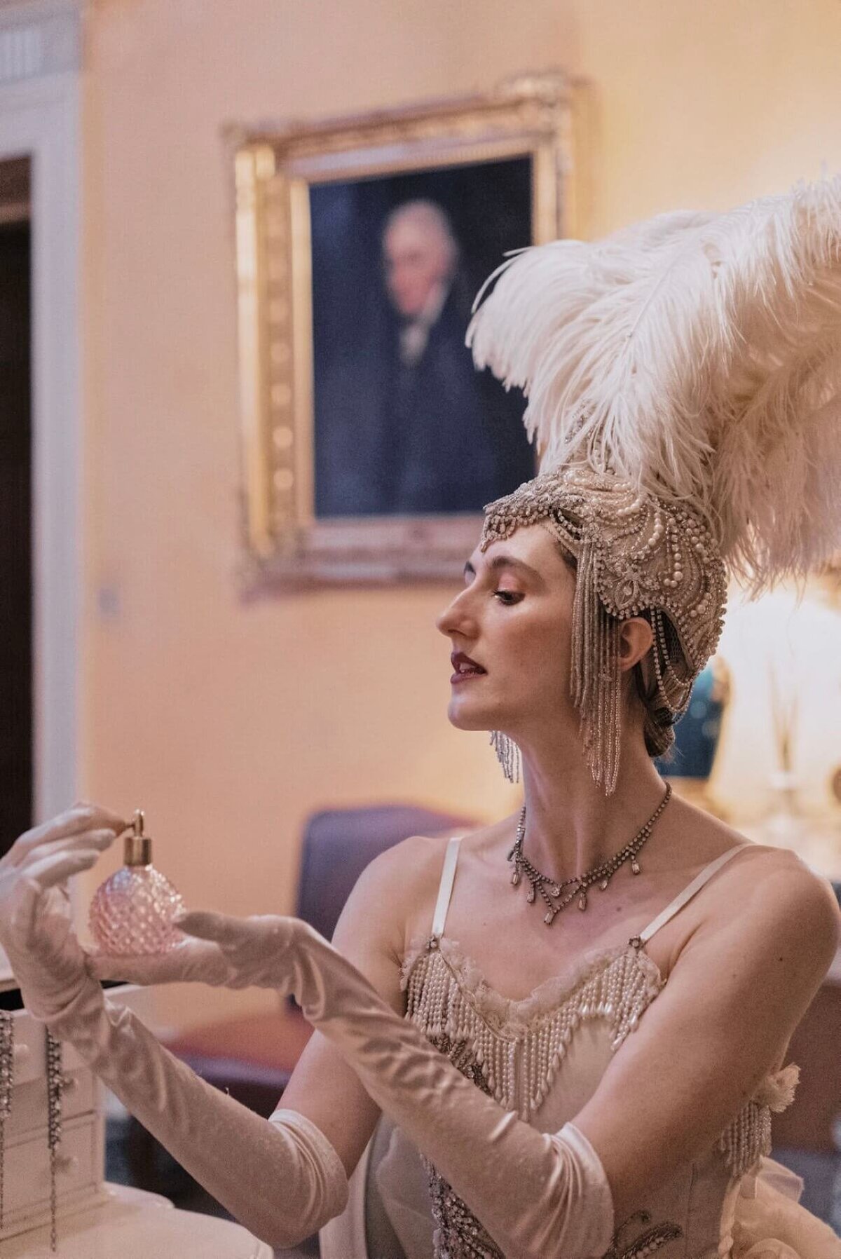 Entertainer with feather hat spraying perfume on herself