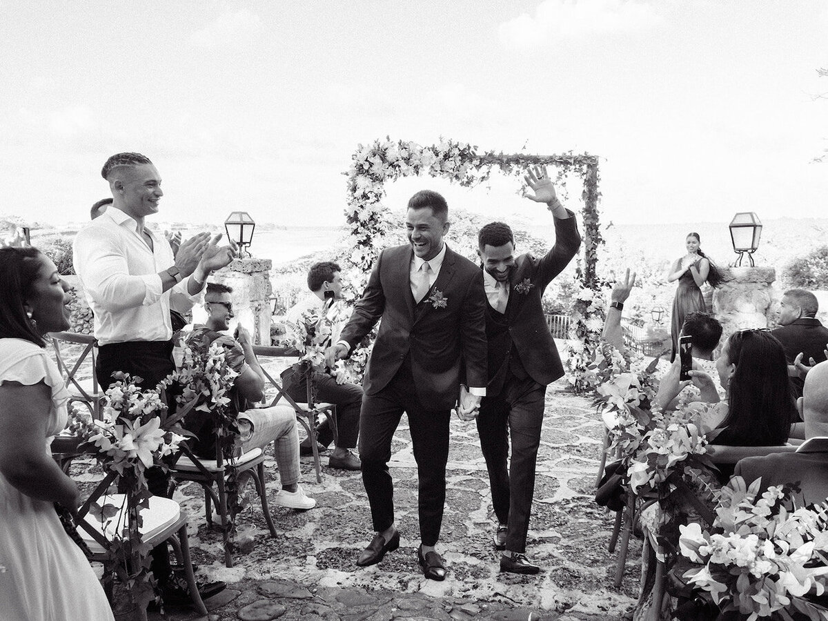 Gay couple walking down the aisle during ther destination wedding ceremony