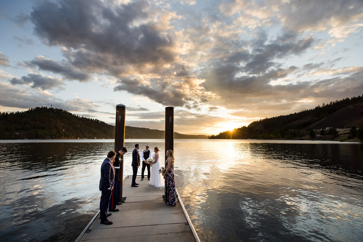 A small intimate elopement on a Lake Coeur d'Alene dock at sunset after a summer storm in Coeur d'Alene, Idaho.