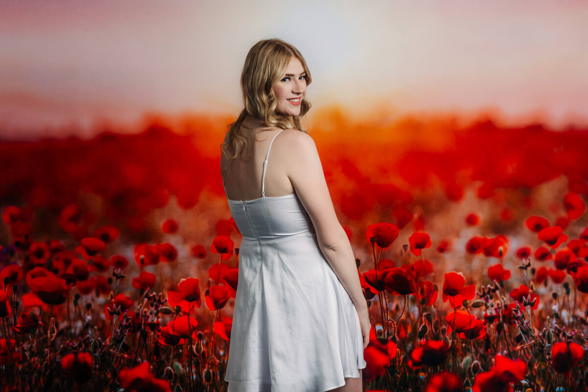 Embry Riddle senior poses in front of red poppies in Prescott senior photos