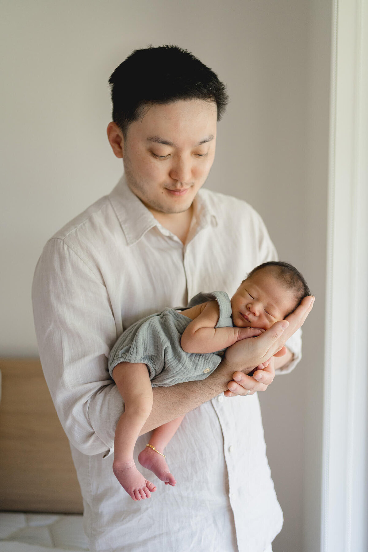 Witness the beauty of parenthood as a Chinese dad embraces their newborn in a heartwarming Gold Coast maternity shoot.