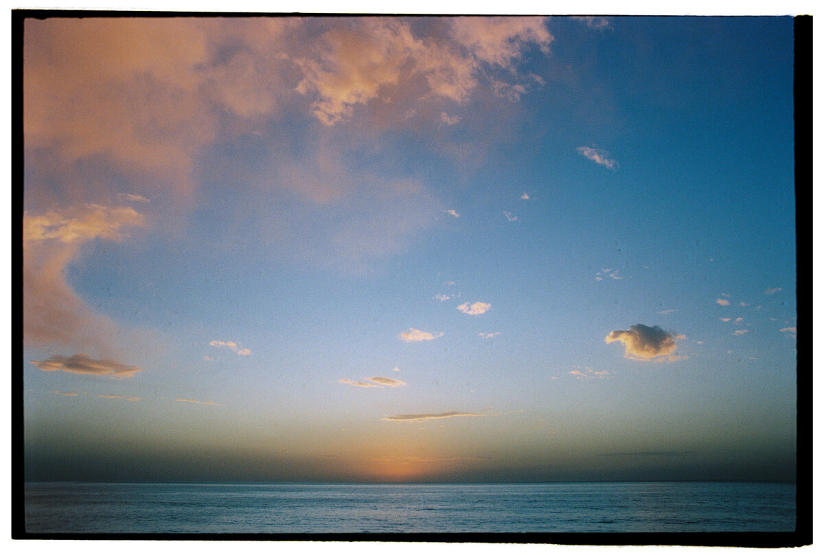 Sunset viewed from a cliff, captured in an authentic and candid style by Kate Winters Photography, Carmel, CA.