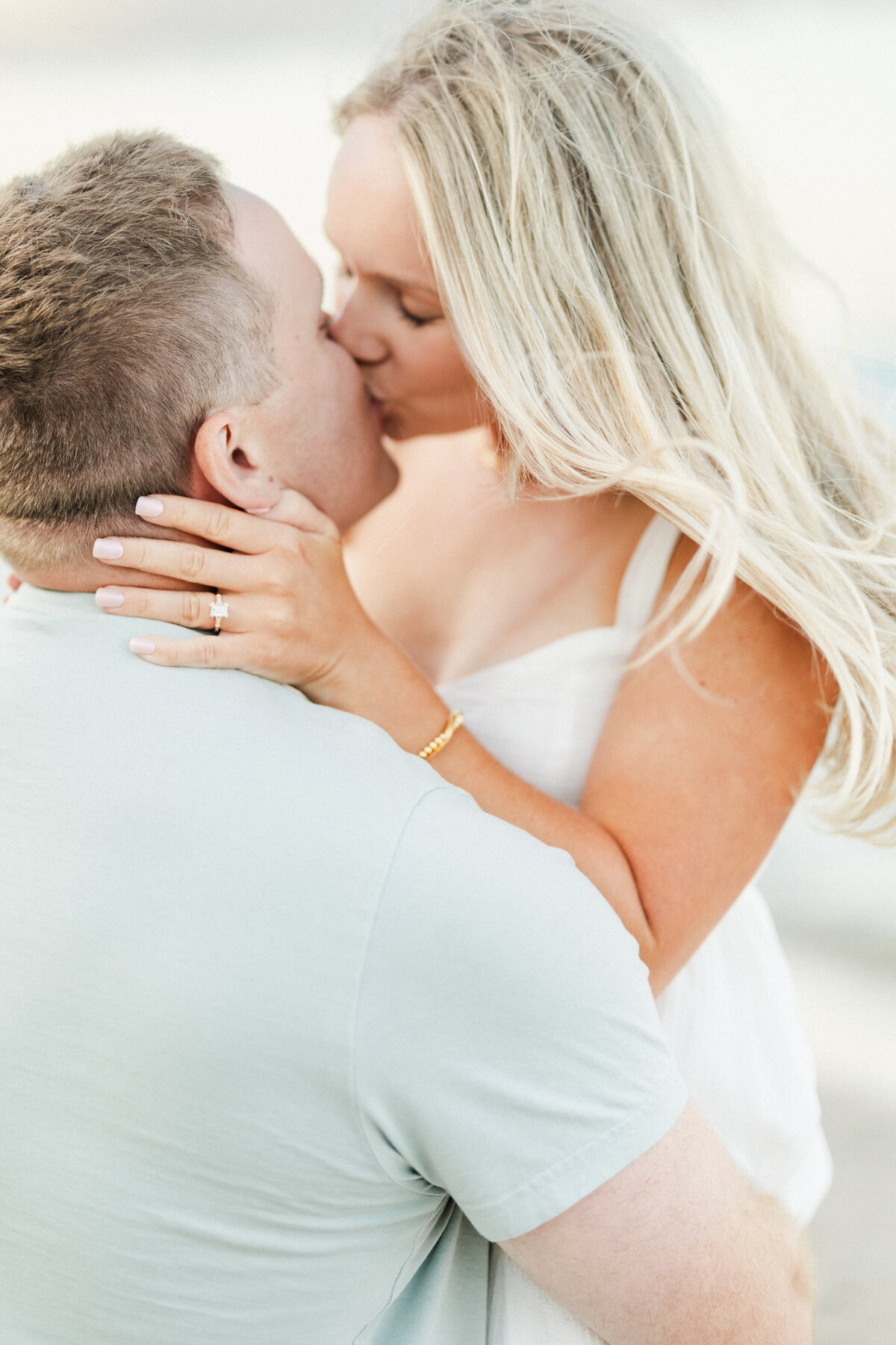 32_Engaged_couple_kissing_radiant_emerald_cut_engagement_ringjpg