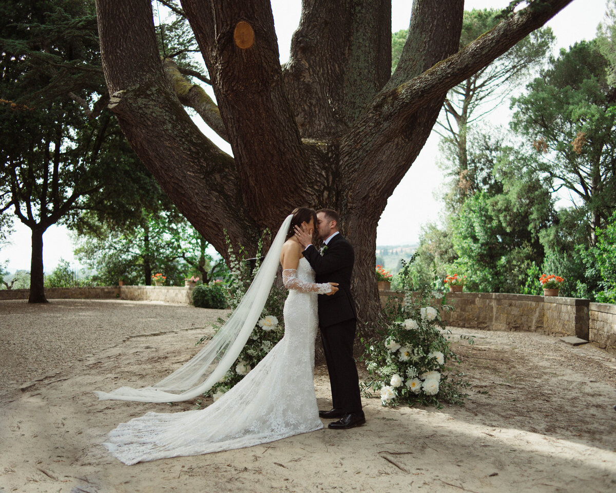 Bride and groom kiss during their wedding ceremony at Castello il Palagio