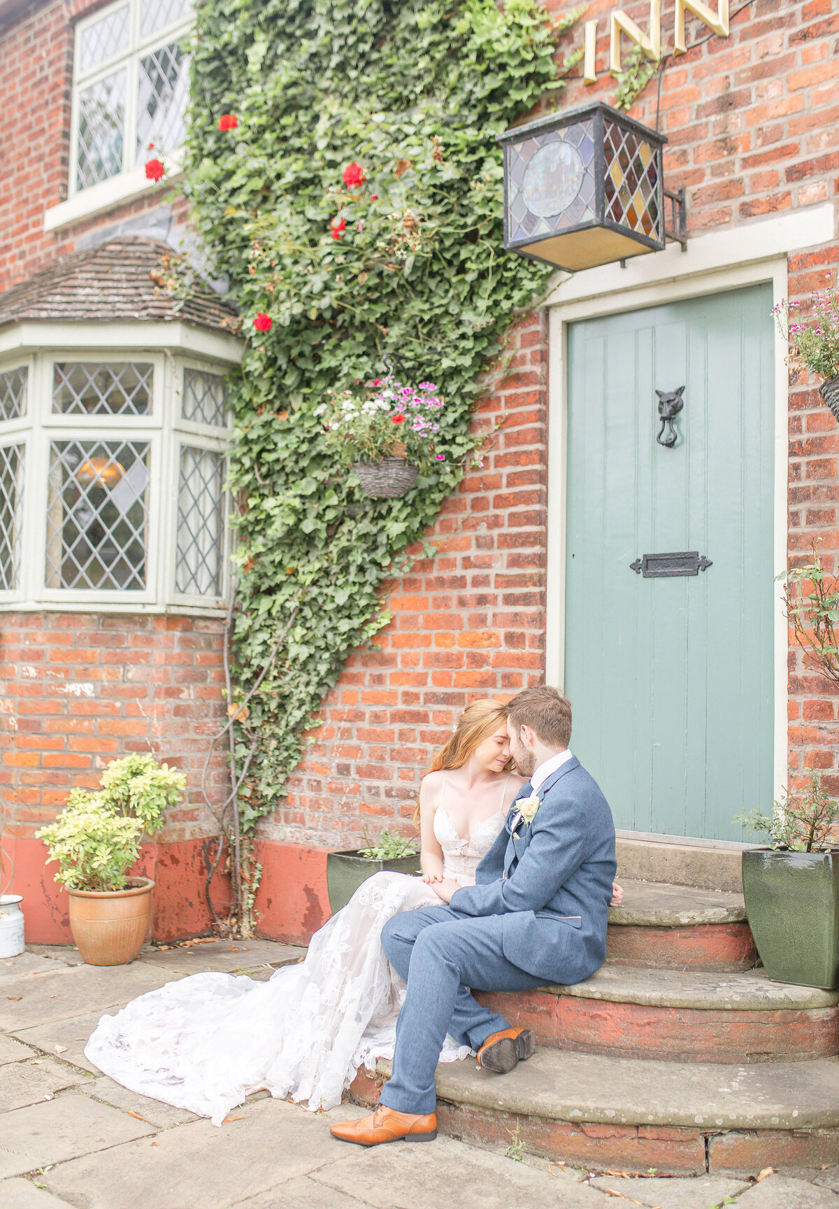 Bride and groom sat on steps outside The Plough Inn Eaton Congleton