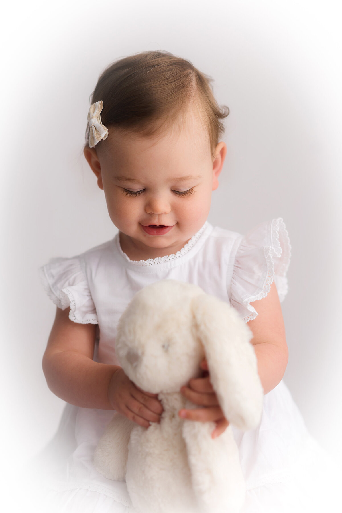 Baby plays with a stuffed bunny during Heirloom Photography session in Charleston, SC Photo Studio.