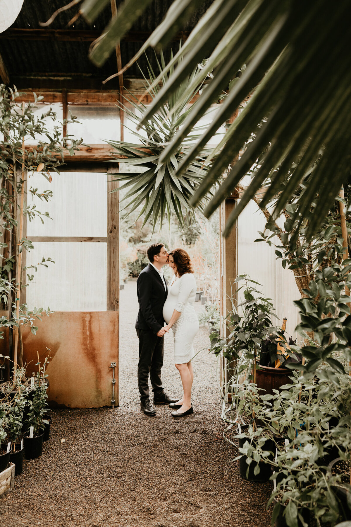 pregnant couple in a greenhouse