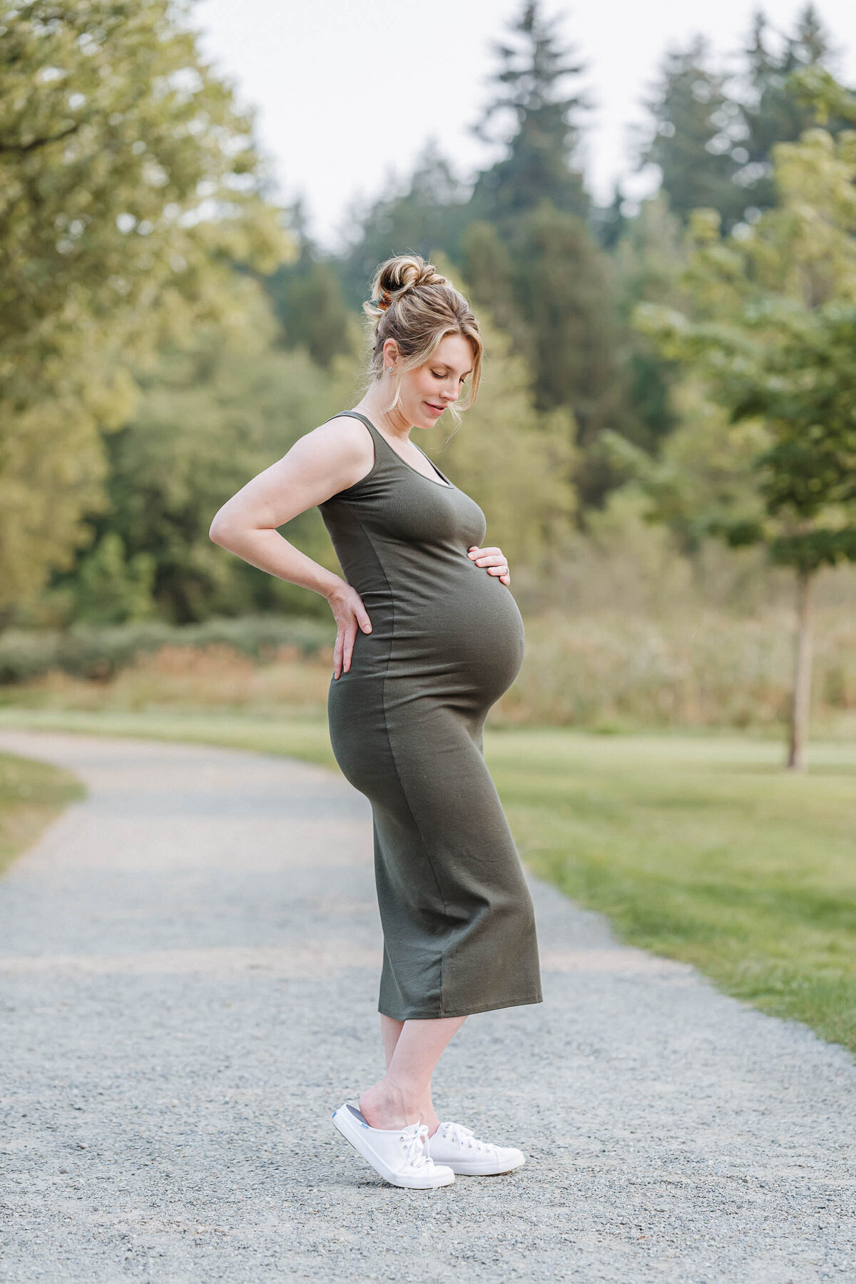 Pregnant mother looking down at her belly with love and anticipation during a quiet moment in her maternity session.