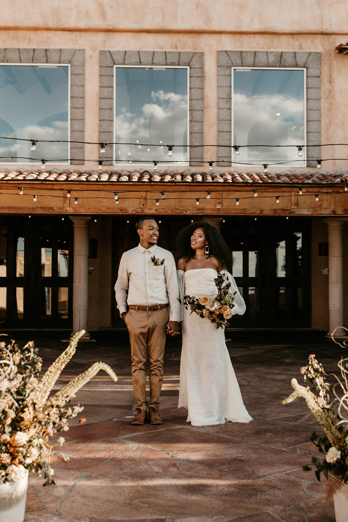 bride and groom standing together in front of a southwest building