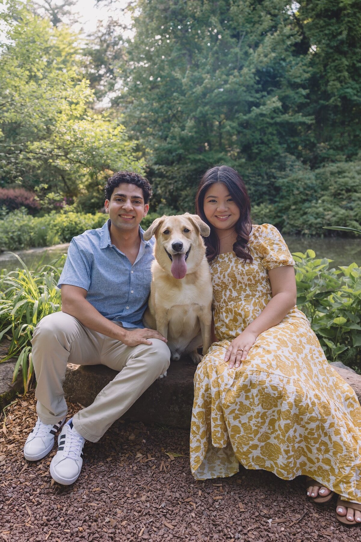 Couple sitting with their dog at Sayen Gardens during engagement session.