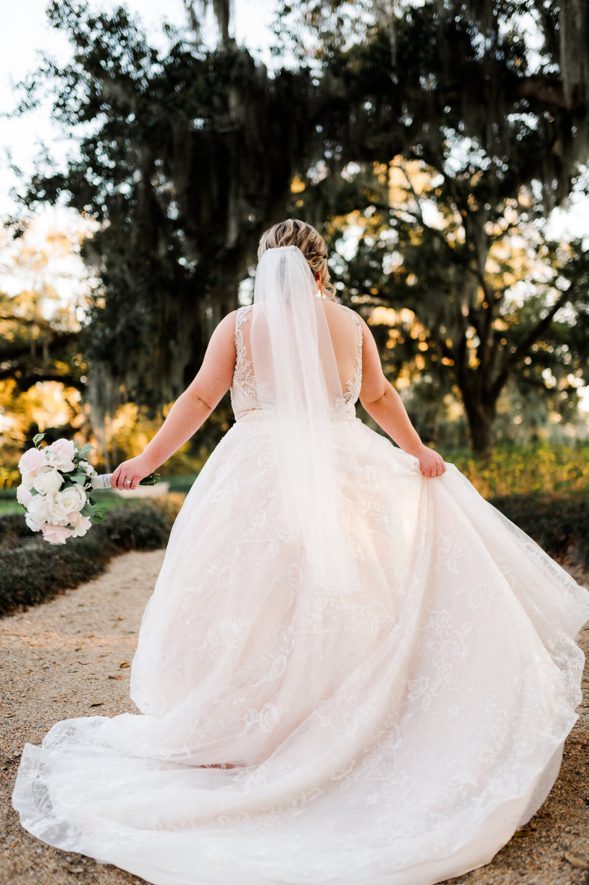 bride dancing down a gravel path at sunset at her outdoor little rock ar wedding venue
