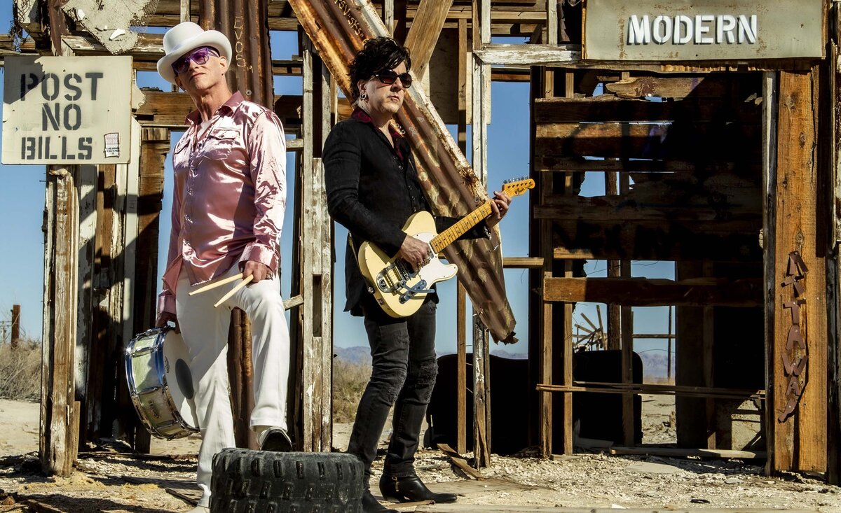 Musical duo photo 7horse standing holding instruments against wood house frame backdrop