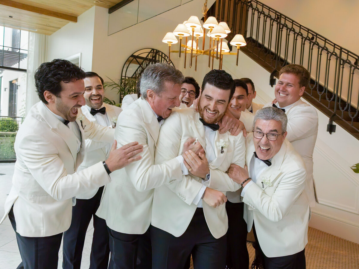 Nick laughing with his groomsmen in white dinner jackets at Pendry Natirar