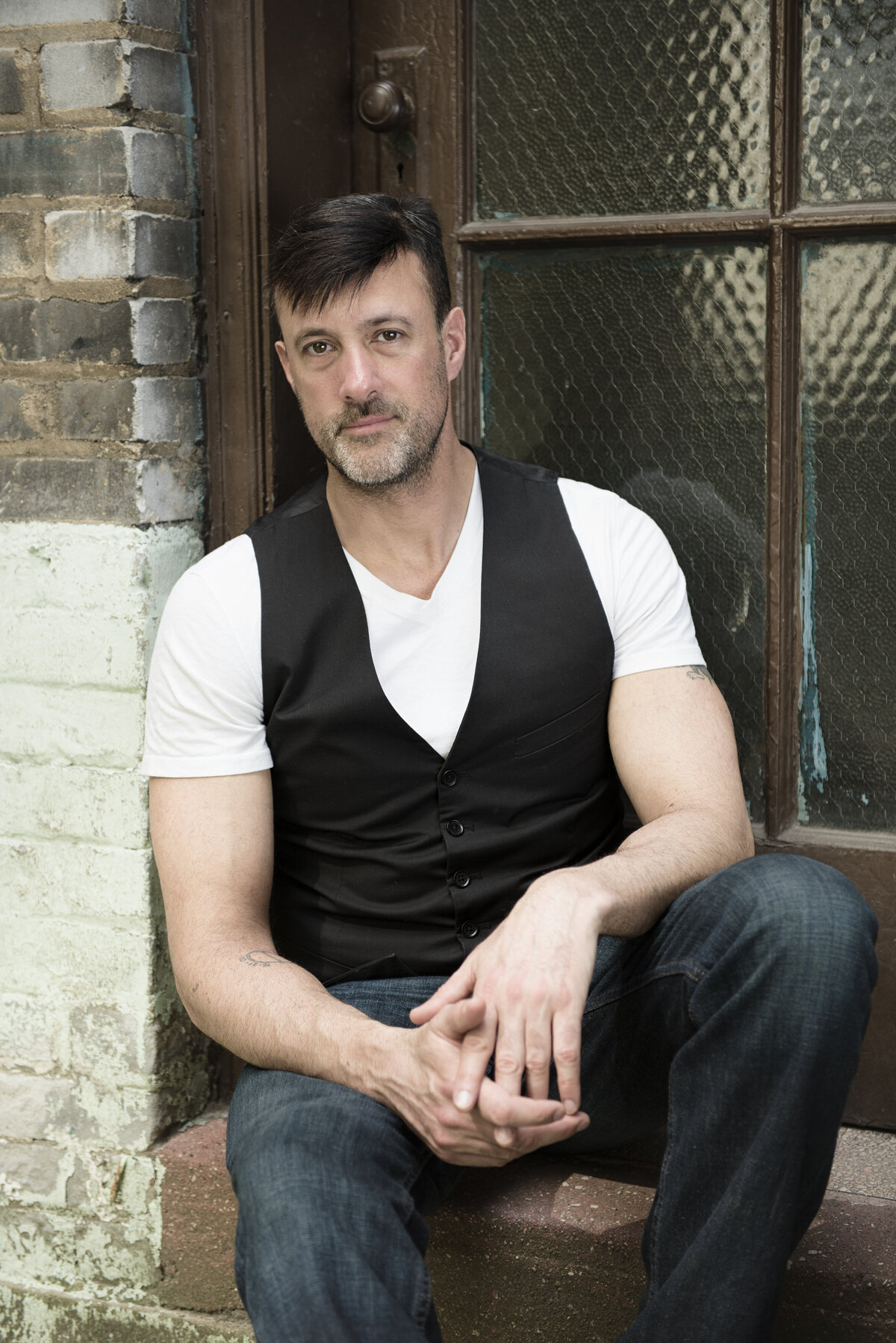 A man sitting in an outdoor windowsill