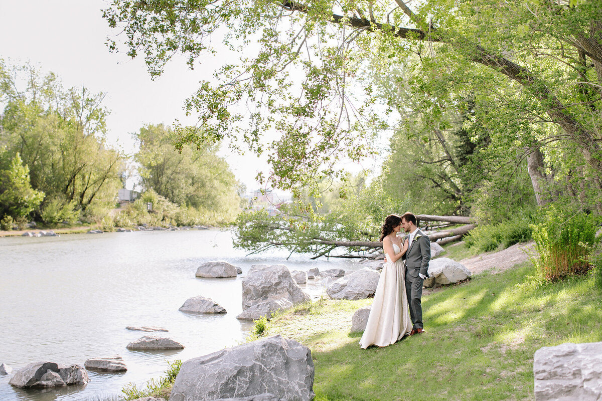 Couple near the water at River Cafe, a riverside wedding venue in downtown Calgary, featured on the Brontë Bride Vendor Guide.