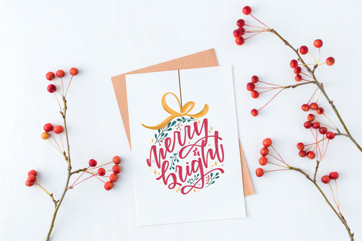 Custom holiday card with words "merry and bright" in the shape of an ornament