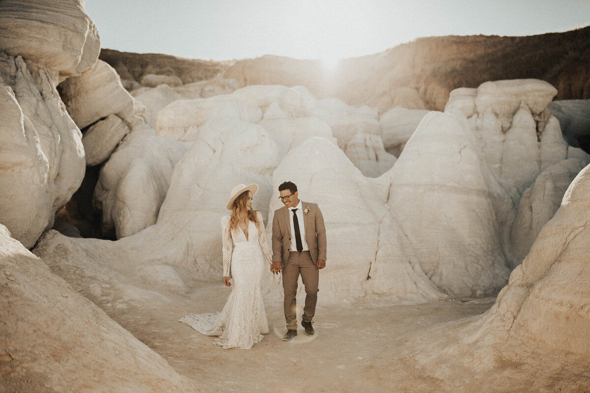 Bride and groom walking in canyon