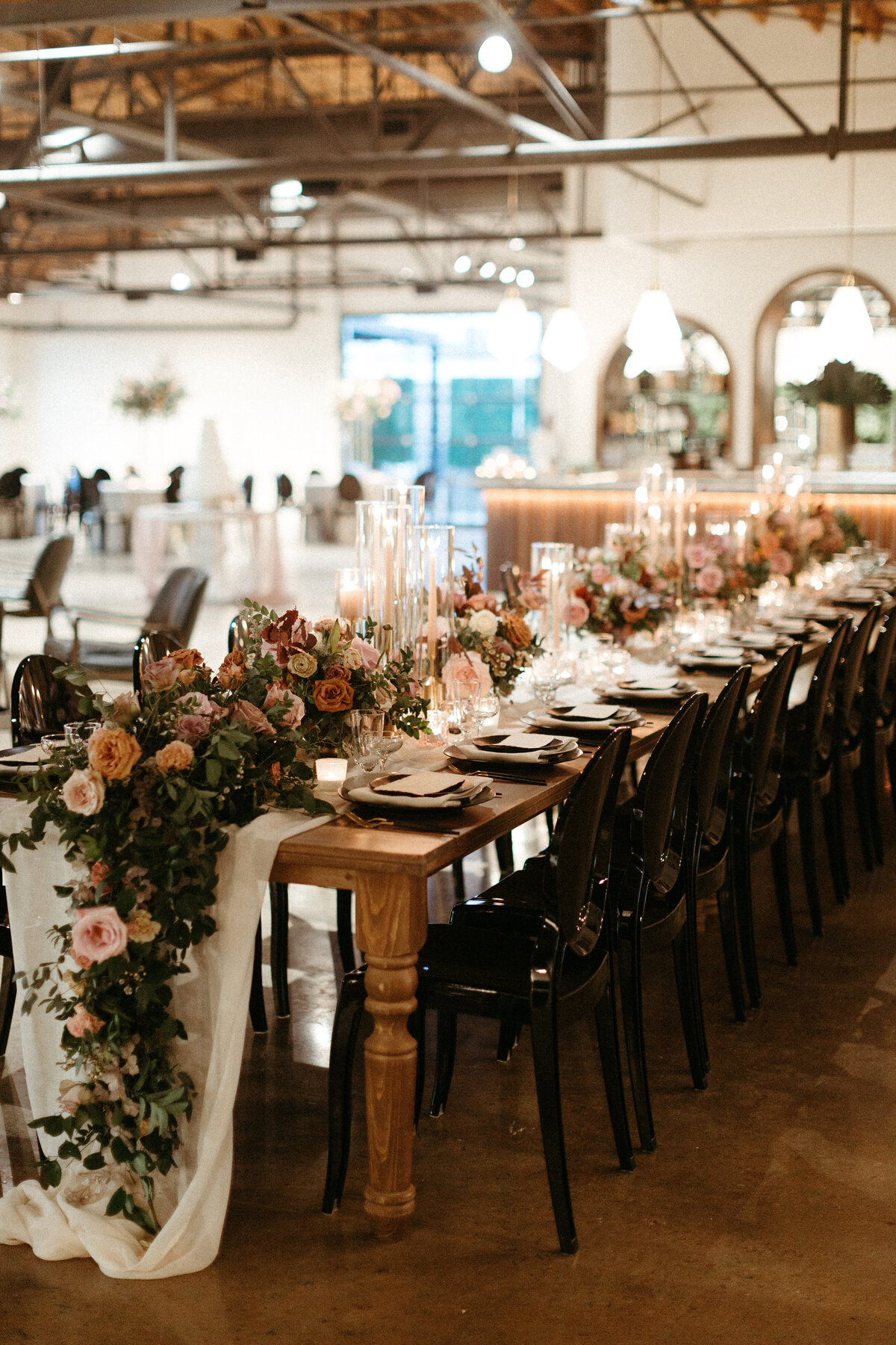 Beautiful floral cascades decorate the tables of this art deco wedding. Petal heavy roses, dried branches, and greenery bring floral hues of terra cotta, dusty pink, burgundy, and sage green. Designed by Rosemary and Finch in Nashville, TN.