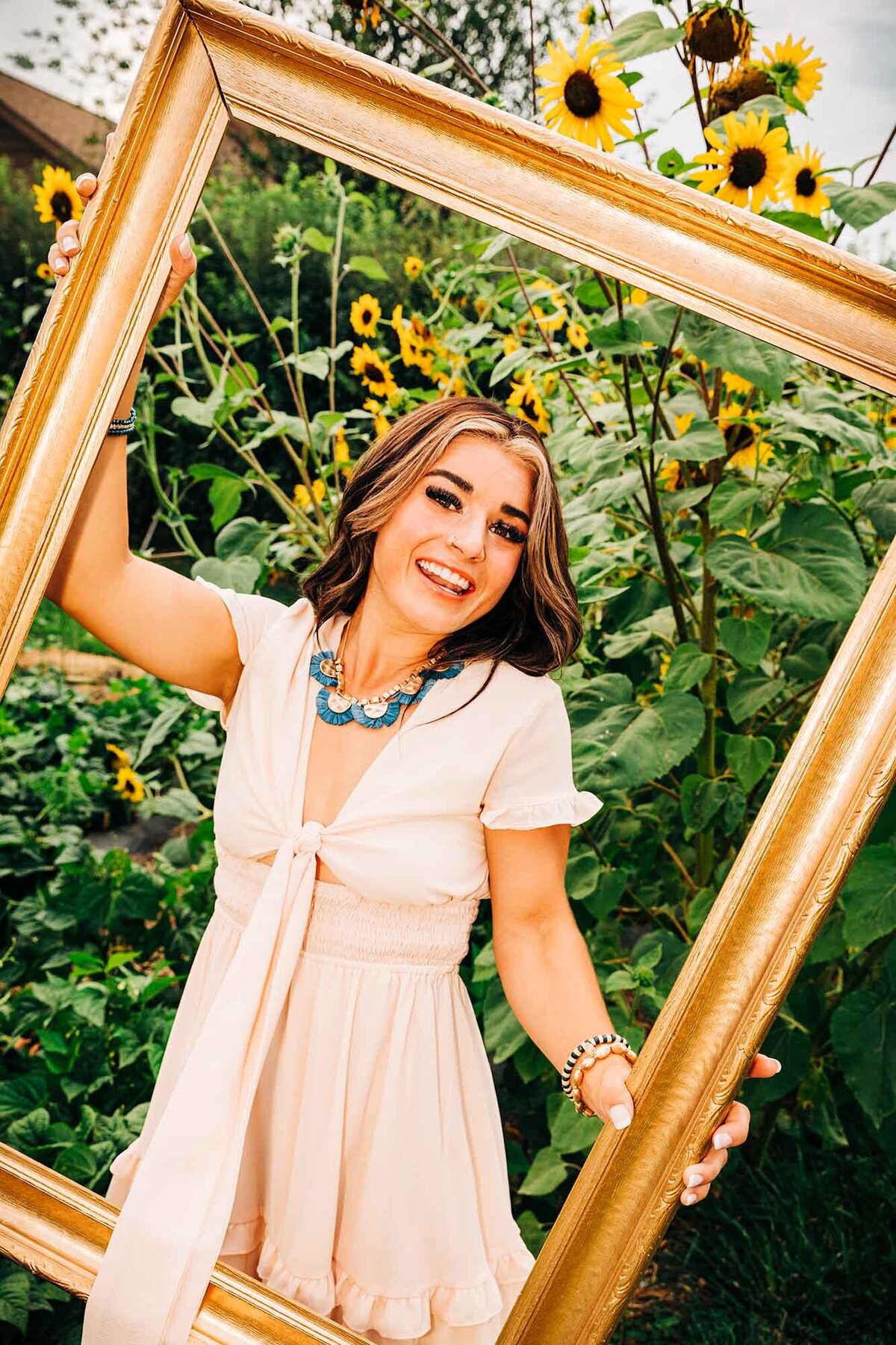 Senior photo of Missoula girl holding large picture frame at Turner Farms