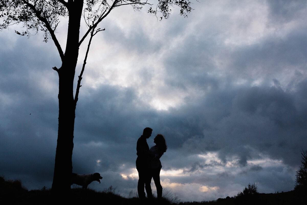 A silhouette of a couple and their dog during their engagement shoot in West Yorkshire