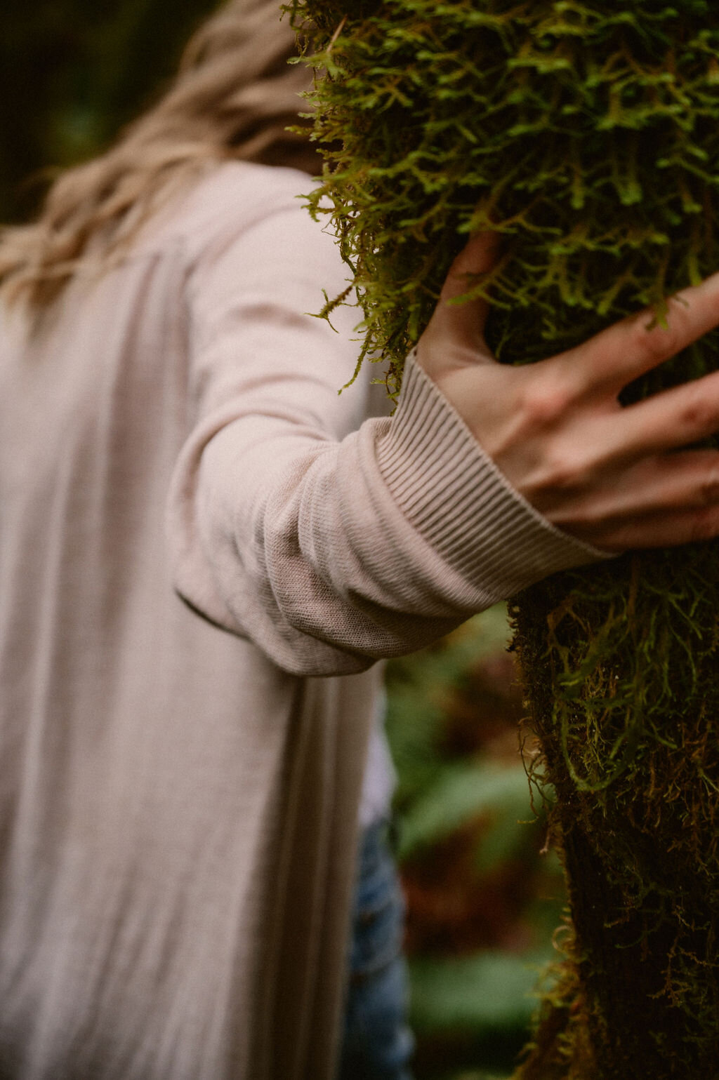 Woman holding mossy tree in Port Alberni