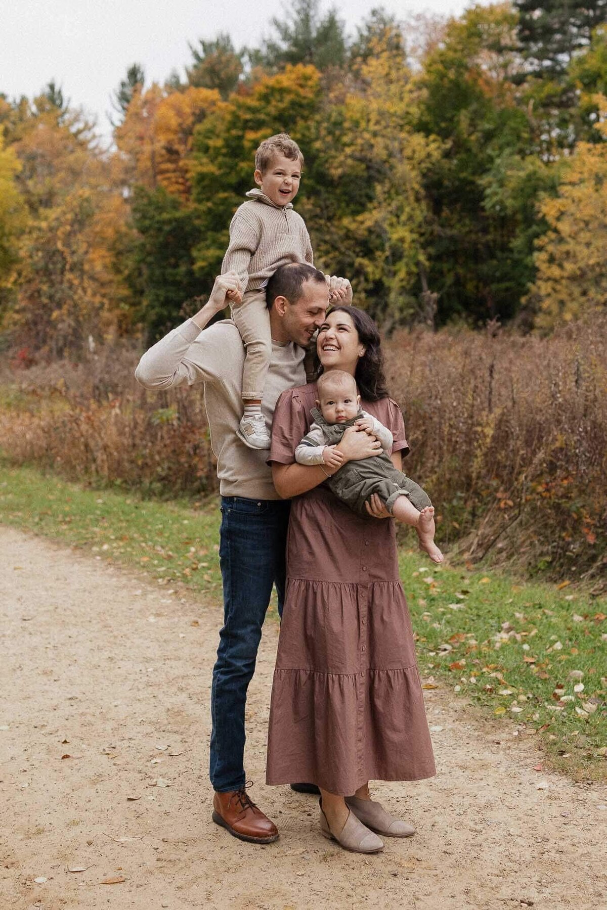 Family snuggling in a field during a fall family photography session at Cleveland Metropark.