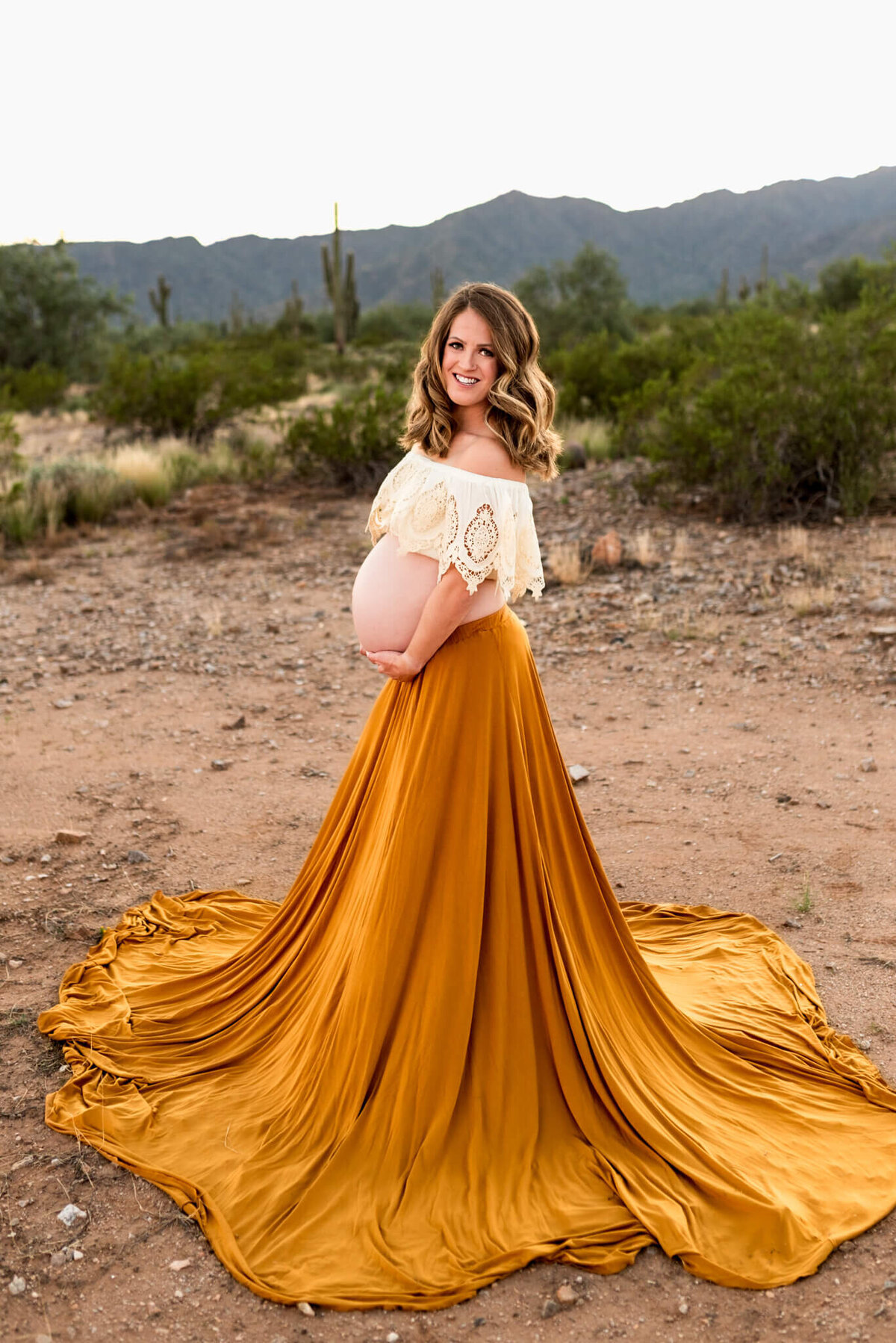 mother-to-be holding uncovered baby bump for maternity portrait. Styled by Cactus & Pine Photography