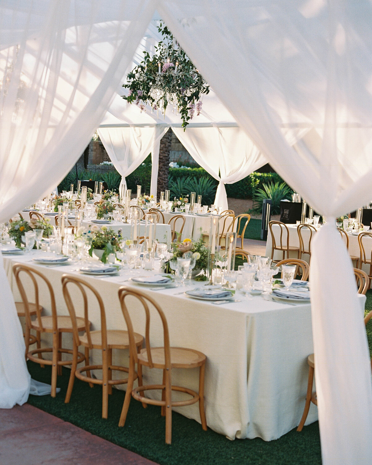 Luxury wedding photographer capturing an exquisite outdoor wedding reception with floral table settings, candlelight, and elegant details.