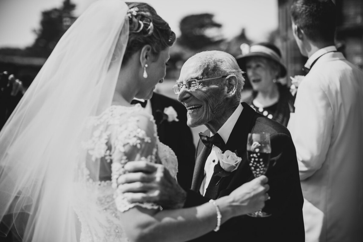 grandad congratulating a bride who has just got married in black and white