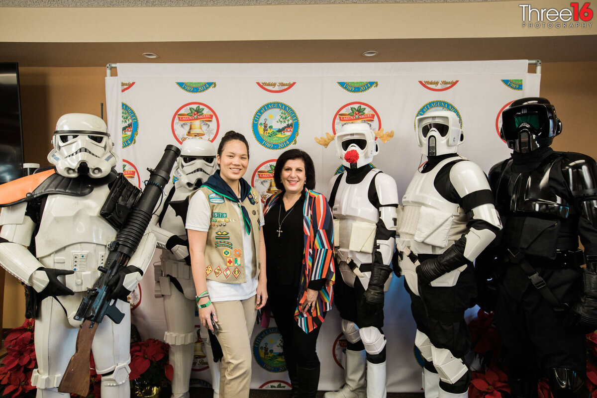 Scout member poses at an event with her mother, Darth Vader and Stormtroopers