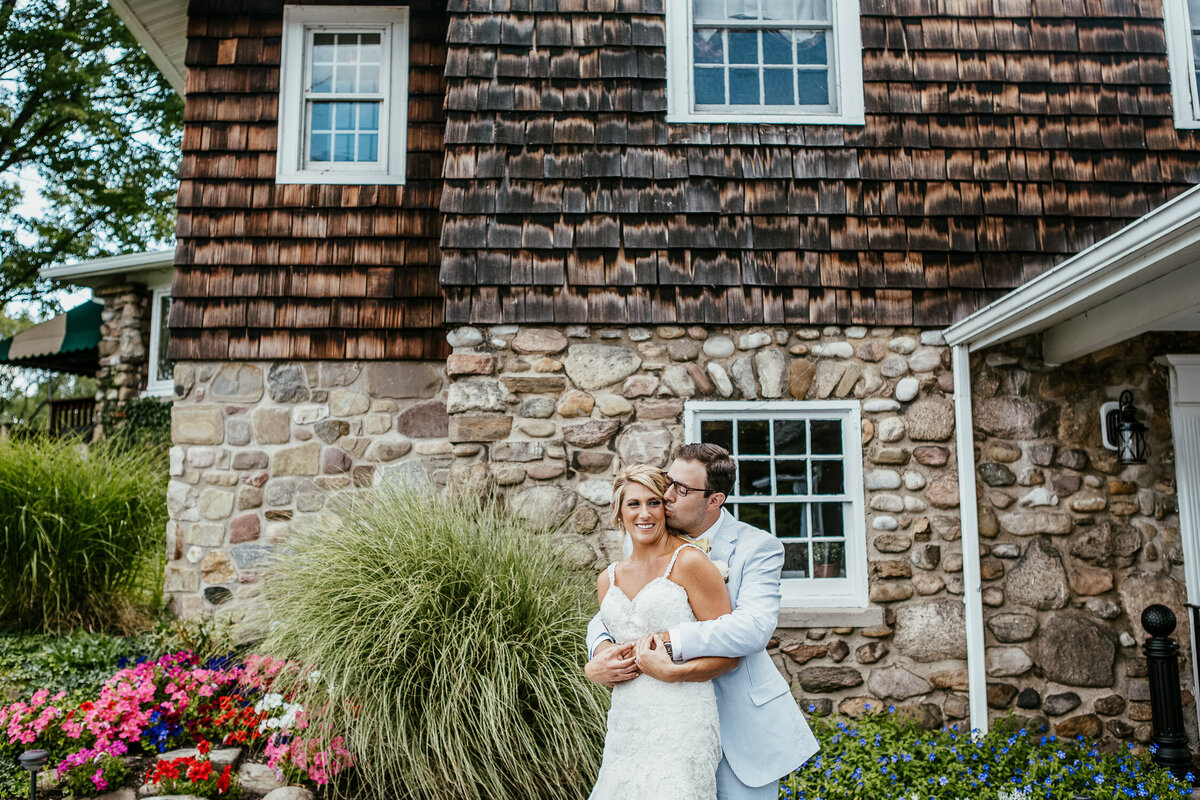 Bride & Groom kissing in front of country club stone building in Buffalo