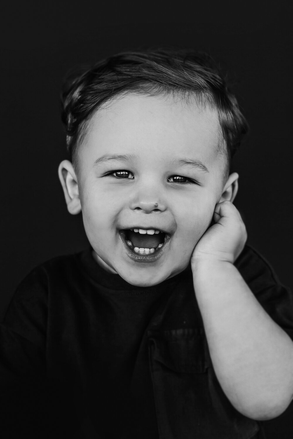 Portret lachende  jongen op donkere achtergrond